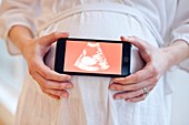 Pregnant woman holding baby scan
