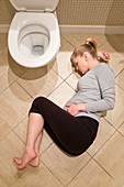 Pregnant woman lying on bathroom floor