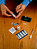 Diabetic taking blood sample for glucose testing