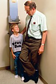 Boy being measured after growth hormone therapy