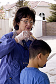 School nurse examines student for lice