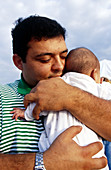 Hispanic man holds baby