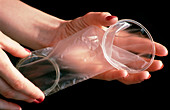 Female condom (Femidom) held in a woman's hands