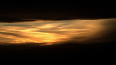 Sunset through mountain clouds, timelapse