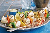 Grilled halibut kebabs with pepper and lemon wedges on a bed of rice