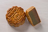 Two Chinese mooncakes, one whole and one cut in half