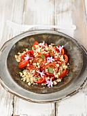 Geriebener Parmesan mit Tomaten, Basilikum und Knoblauchblüten