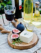 Goats' cheese, fresh figs and honey on a wooden board