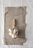 Garlic bulbs tied together on a linen cloth (seen from above)