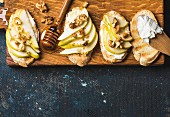 Crostini with sliced pear, ricotta, honey and walnuts