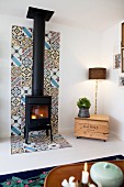 Wood-burning stove on strip of patterned tiles on wall and floor