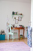 Turquoise chair in front of semi-circular desk in child's bedroom