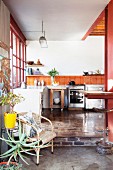 Offener Küchenbereich mit recyceltem Parkettboden und orangefarbenen Wandfliesen in Loftwohnung