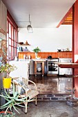 Recycled parquet floor and orange wall tiles in open-plan kitchen of loft apartment