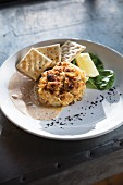 A crab cake with remoulade sauce and salted crackers