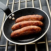 Three Italian sausages (salsiccia) in a frying pan