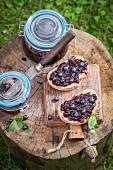 Bread topped with blueberry jam on a wooden board in the garden