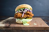 A burger with fried chicken and herb dressing