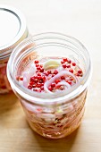 Shallots pickled in vinegar in a preserving jar