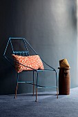 Delicate metal chair with leopard-print cushion against dark wall