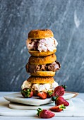 A pile of doughnut ice cream sandwiches with strawberries