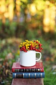 Flowers and berries in an enamel jug as an autumn decoration