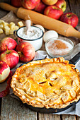 Apple pie with a pastry topping, surrounded by the ingredients