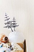 Cut-out Christmas trees stuck on white baubles
