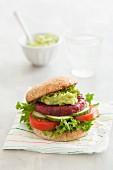 A veggie burger with a beetroot patty and avocado spread