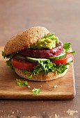 A veggie burger with a beetroot patty and avocado spread