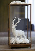 Stag figurine dipped in plaster and arranged with meringues in glass case