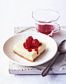 A slice of cheesecake with raspberries