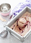 An ice cream tub with milk chocolate and blackberry ripple ice cream