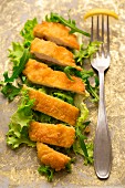 A gluten-free chicken escalope on a bed of lettuce