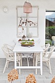 Old window frame above white table and chairs on terrace