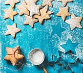 Sweet gingerbread cookies in shape of star with sugar powder on bright blue painted plywood background