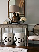 Buddha statue on console table above two stools