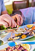 A person using their hands to eat crab
