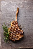Grilled beef barbecue Veal rib Steak on bone on stone slate background