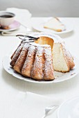 A freshly baked Bundt cake with icing sugar and vanilla pods
