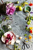 Frame of decorative flowers, florets, fruit and vegetables on stone surface