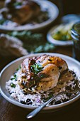 One roasted game hen served on top of black bean rice