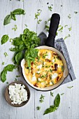 A frittata with basil in a frying pan