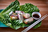 Asian rice paper rolls with duck, cheese and melon served on lettuce leaves