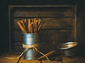 Cinnamon sticks in metal jar on wooden table