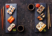 Assorted sushi (Maki and Nigiri) for two on a dark surface