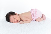 Newborn baby girl in pink nappy,asleep