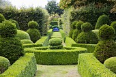 Blaue Bank am Ende eines Weges im klassischen Formgarten