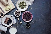 Zutaten für Chai-Tee (Milch, Pfeffer, Zimt, Ingwer, Muskatnuss und Kardamom)