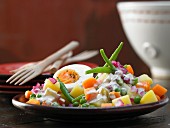 Vegetable salad with tuna sauce and a hard-boiled egg